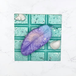 Purple feather on a green and white wax melt