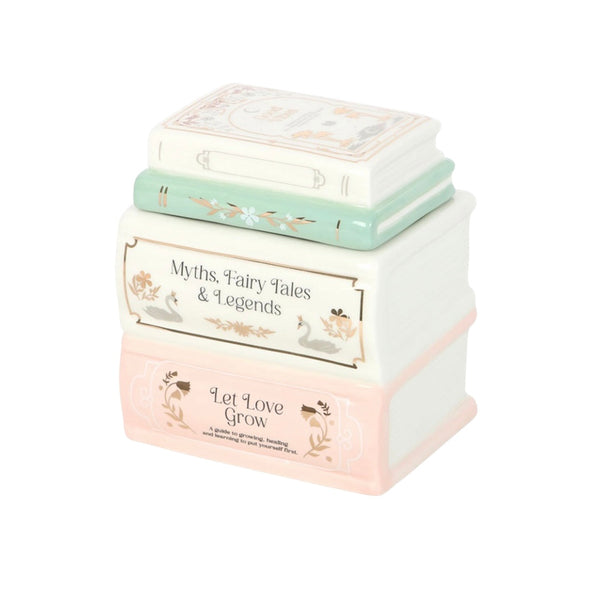 Stack of decorative boxes with fairy tale-themed text on a white background -oil burner- wax melter
